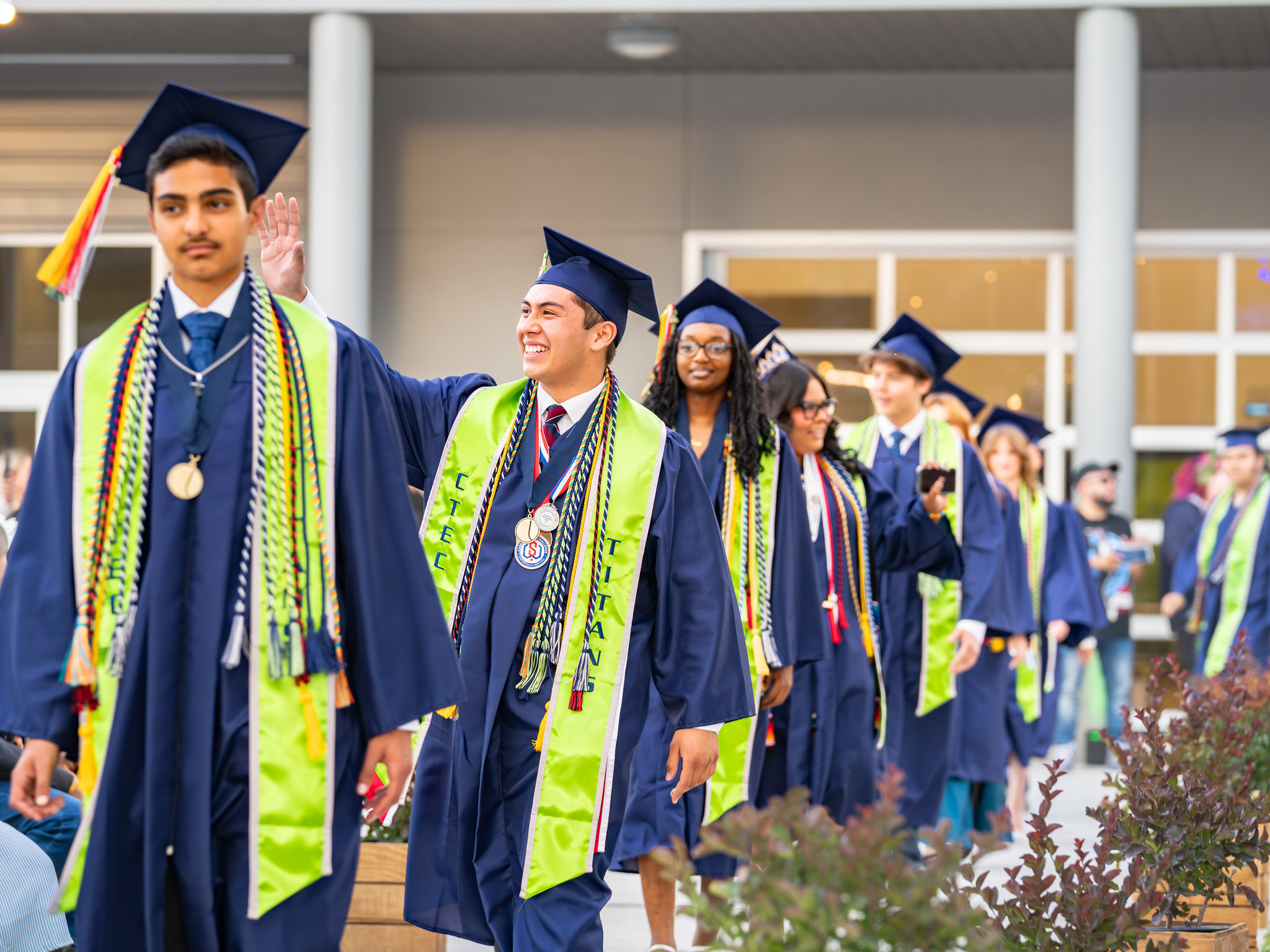 Students walking in graduation caps and gowns